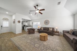 a living room with couches and a ceiling fan at IAH Place: 4 bed, patio-sleeps 8+ in Humble