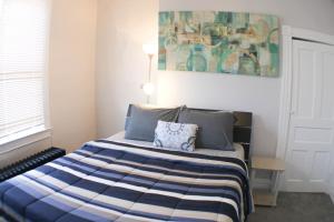 a bedroom with a bed with a blue and white blanket at 3 BR - Off Street Parking - Amazing View Nearby in Pittsburgh