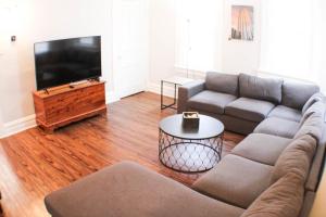 a living room with a couch and a flat screen tv at 3 BR - Off Street Parking - Amazing View Nearby in Pittsburgh