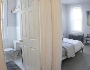 a bedroom with a bed and a door with a toilet at 3 BR - Off Street Parking - Amazing View Nearby in Pittsburgh