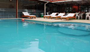 una piscina con sillas y una pelota en el agua en Hotel Bella Costa en La Lucila del Mar