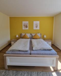 a bedroom with a large bed with yellow walls at Modern eingerichtet-stadtnah-Ferienwohnung mit Geschirrspüler und Waschmaschine in Friedland