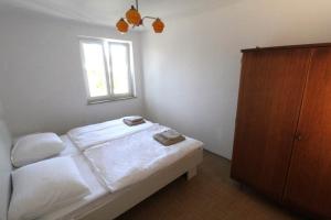 a bedroom with a bed with white sheets and a window at Mia apartments in Savudrija
