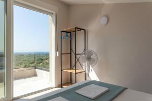 um quarto com uma mesa e uma grande janela em STO LOFO Apartments Kalyvia-Limenaria Thassos em Limenaria