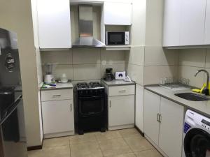 a small kitchen with a stove and a microwave at The Wall Montevideo [203] Vive en la Ciudad Vieja in Montevideo