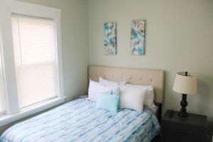 1 dormitorio con 1 cama con almohadas azules y blancas en Comfy 3 BR - Family Friendly Apt - City Access, en Pittsburgh