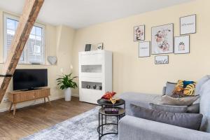 uma sala de estar com um sofá e uma televisão em Suite Studio nah Messe & Rhein I Netflix I Küche em Krefeld