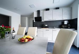 Una cocina con una mesa con un bol de fruta encima. en Blauer Stein 7a WH01 - Apartment 3 SZ, 5 Betten, en Pulheim