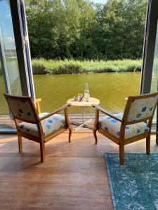 een tafel en twee stoelen op een veranda met een tafel bij BB de Woonboot in Anna Paulowna