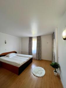 - une chambre avec un grand lit et du parquet dans l'établissement Roua Muntelui, à Sărata-Monteoru