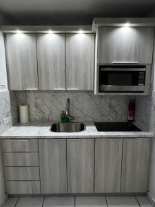 une cuisine avec un évier et un micro-ondes dans l'établissement Isla Verde Puerto Rico, One Queen Bed, à San Juan