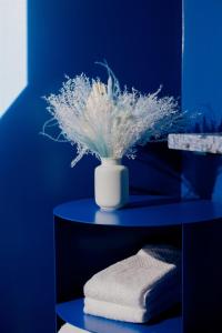 a blue room with a vase with a plant on a shelf at The Norsdale plus CMYK Motel on 10 acres in Phoenicia in Phoenicia