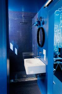 a blue bathroom with a sink and a mirror at The Norsdale plus CMYK Motel on 10 acres in Phoenicia in Phoenicia +105 photos