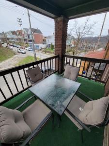 een tafel en stoelen op een balkon met uitzicht op een straat bij Comfy and Spacious 3 BR - Easy City Access in Pittsburgh