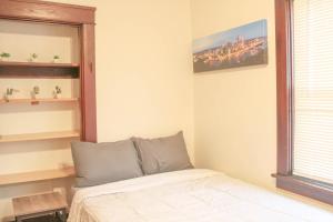um quarto com uma cama, um espelho e uma janela em Comfy and Spacious 3 BR - Easy City Access em Pittsburgh