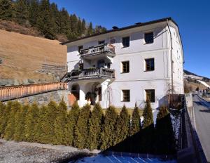 un gran edificio blanco con árboles delante de él en Ferienwohnungen Peisserhof en Sillian