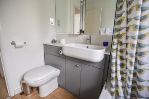 ein Badezimmer mit Waschbecken, Toilette und Spiegel in der Unterkunft Whiteleaf Cottage in Lyme Regis + 13 Fotos