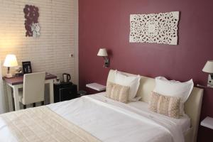 - une chambre avec un grand lit blanc et un bureau dans l'établissement Hôtel Beausoleil, à Montélimar