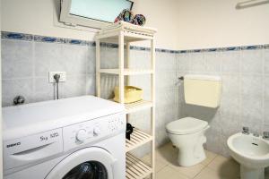 a bathroom with a washing machine and a toilet at Casa stella in San Lorenzo al Mare +13 photos