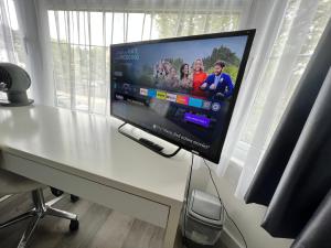 a flat screen tv sitting on top of a desk at Comfortable Double Room for One Person in Hither Green