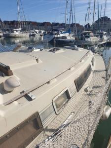 a boat docked in a marina with other boats at Détente insolite sur un bateau a Cabourg in Dives-sur-Mer