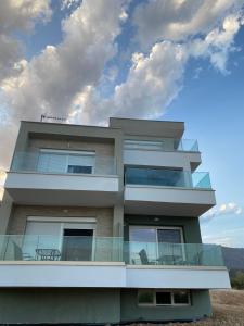 a tall building with a table on the balcony at STO LOFO Apartments Kalyvia-Limenaria Thassos in Limenaria