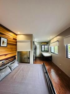 1 dormitorio con 1 cama grande y pared de madera en Z-Pad, en Bacolod