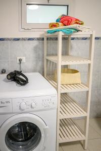 a white shelf next to a washing machine at Casa stella in San Lorenzo al Mare