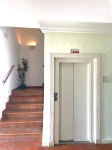 a hallway with a white door and stairs at Hotel La Lampara in Reggio di Calabria