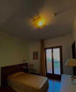 a bedroom with a bed and a light on the ceiling at Hotel La Lampara in Reggio Calabria