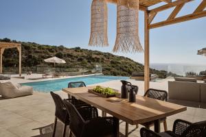 comedor con mesa y piscina en Elle Lux Villa, Essence of Endless Blue, By ThinkVilla, en Agios Nikolaos