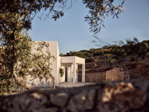 una casa blanca en una colina con árboles en Elle Lux Villa, Essence of Endless Blue, By ThinkVilla, en Agios Nikolaos