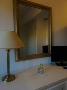 a lamp sitting on a desk with a mirror at Hotel La Lampara in Reggio Calabria