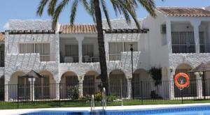 un gran edificio blanco con una piscina frente a él en Apartamento Rio Marinas Nerja 46, en Nerja