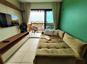 uma sala de estar com um sofá e uma varanda em VG Sun Cumbuco Sea Breeze Vista Mar em Cumbuco