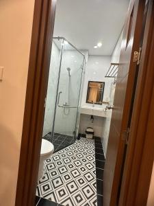 uma casa de banho com chuveiro e piso em azulejo preto e branco em Wins House - khách sạn em Duong Dong