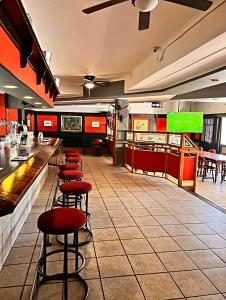 a bar with red stools in a restaurant at Sundown Country Estate in Boshoek