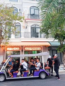 um grupo de pessoas a andar num carrinho de golfe numa rua em Wins House - khách sạn em Duong Dong