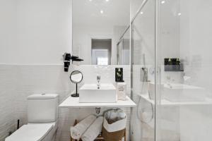 y baño blanco con lavabo y ducha. en limehome Madrid Calle de Nuñez de Balboa, en Madrid