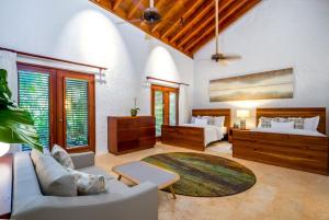 een woonkamer met 2 bedden en een bank bij Sunny Vacation Villa No 39 in San Rafael del Yuma