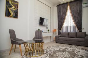 uma sala de estar com um sofá, uma mesa e cadeiras em Hayat Samarkand em Samarkand