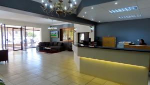 a lobby with a bar with a couch and a person at Sundown Country Estate in Boshoek +65 photos
