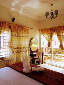 a bedroom with a bed with a mirror and windows at Akkwa 2 Suites in Kololi