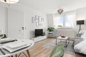 een witte woonkamer met een bank en een tafel bij Design Apartment nah Messe & Rhein I Netflix I Küche in Krefeld