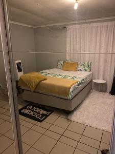 a bedroom with a bed with a window and a rug at Alvin's House in Tsumeb