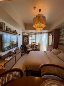 a large bedroom with a large bed and a tv at Suēlo at Azure North Pampanga in San Fernando