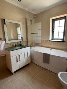 a bathroom with a tub and a sink and a bath tub at Alojamento dos Redondos in Fernao Ferro