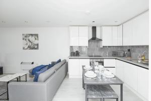 eine Küche und ein Wohnzimmer mit einem Sofa und einem Tisch in der Unterkunft Modern Home in Derby City Centre - Free Gated Parking in Derby