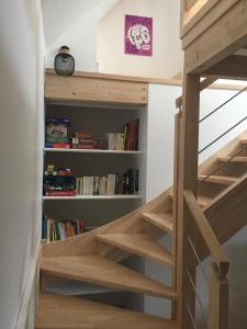 a staircase in a tiny house with bookshelves at La maison de Gwen in Cléden-Cap-Sizun