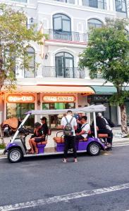 um grupo de pessoas a andar num carrinho de golfe numa rua em Wins House - khách sạn em Duong Dong